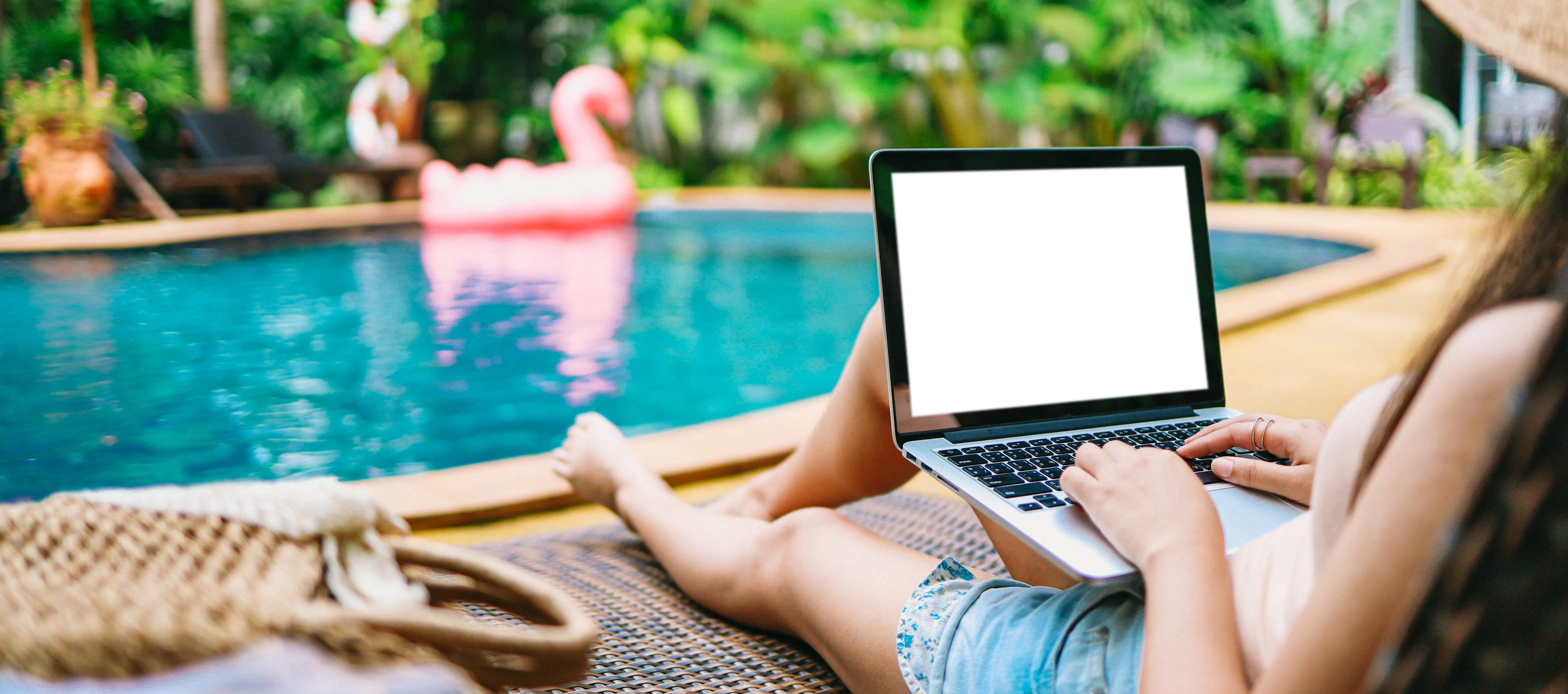 Woman on vacation working on her laptop during a holiday; remote online digital freelance work concept.